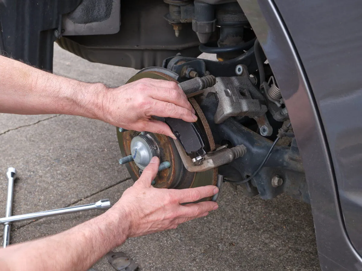 Brake pads being replaced on a car wheel